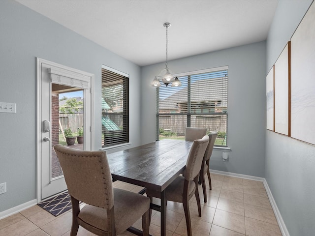 dining space featuring plenty of natural light, a chandelier, light tile patterned floors, and baseboards