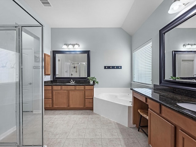 full bathroom with a shower stall, lofted ceiling, a garden tub, tile patterned flooring, and two vanities