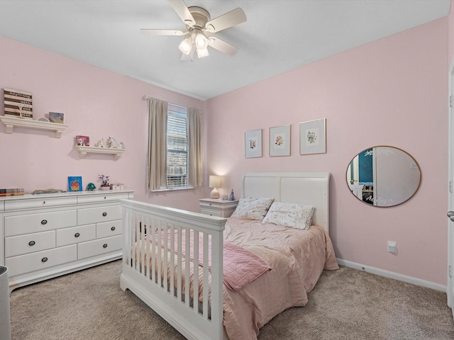 bedroom featuring light colored carpet, baseboards, and a ceiling fan