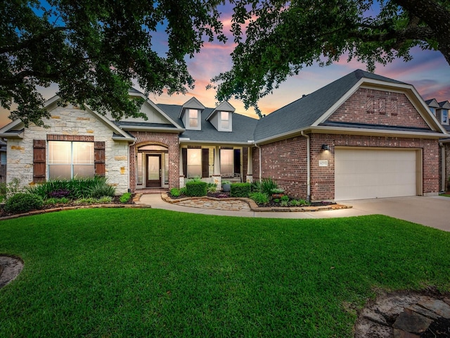 view of front of property featuring a front lawn, a garage, concrete driveway, brick siding, and stone siding