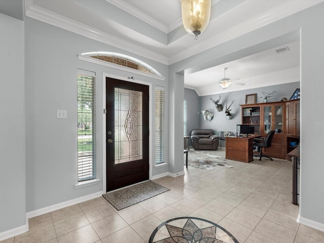 foyer with plenty of natural light, crown molding, ceiling fan, and light tile patterned flooring