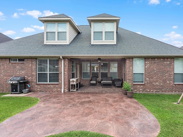 rear view of property featuring brick siding, a patio, a yard, an outdoor living space, and roof with shingles