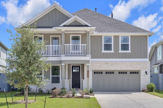 8235 Red Shiner Way, Fulshear, TX 77441 - craftsman-style home featuring board and batten siding, a balcony, driveway, a front lawn, and roof with shingles