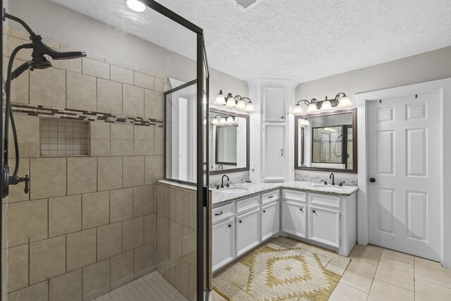 bathroom with a shower stall, tile patterned floors, and double vanity
