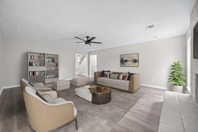 3915 Glenheather Dr, Houston, TX 77068 - living room with stairs, wood finished floors, baseboards, a textured ceiling, and ceiling fan