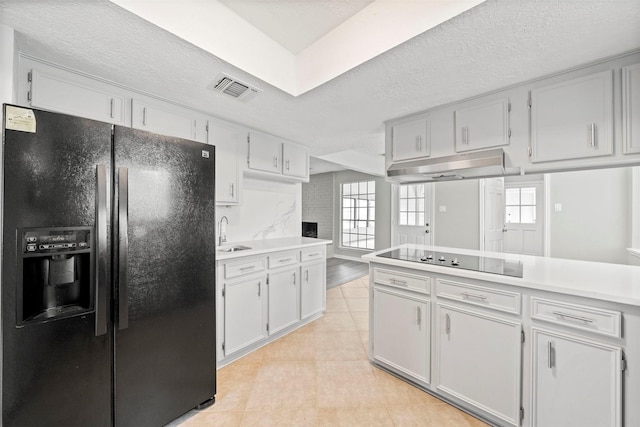 3915 Glenheather Dr, Houston, TX 77068 - kitchen featuring black appliances, under cabinet range hood, light countertops, white cabinetry, and a textured ceiling