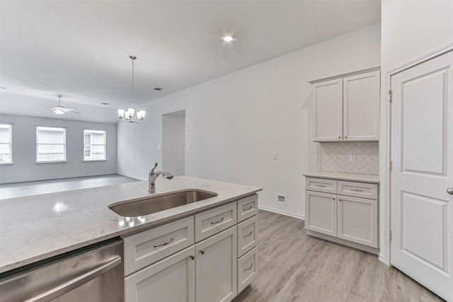 kitchen with dishwasher, a sink, ceiling fan, backsplash, and light wood-type flooring