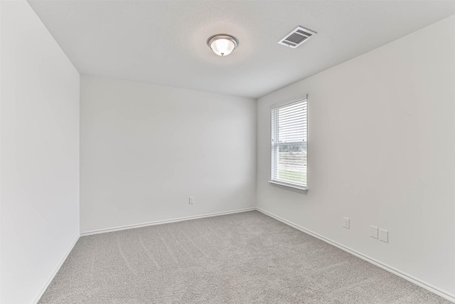 carpeted empty room featuring baseboards