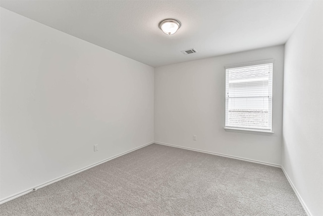 unfurnished room featuring carpet and baseboards
