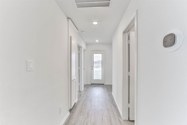 corridor featuring baseboards and light wood-style floors