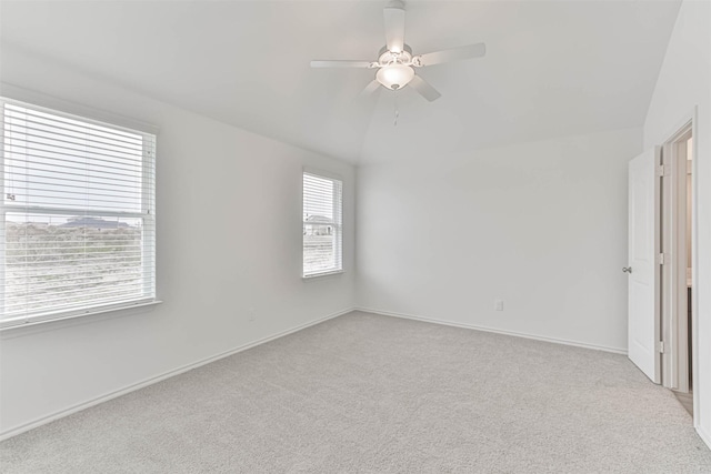 spare room with carpet, vaulted ceiling, a ceiling fan, and baseboards