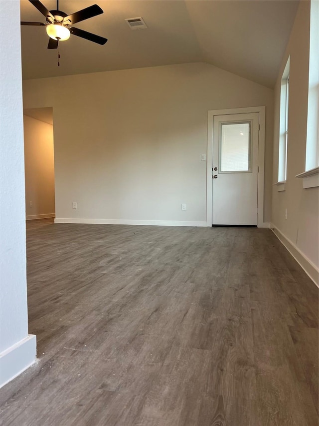 unfurnished living room featuring dark wood finished floors, vaulted ceiling, a ceiling fan, and baseboards