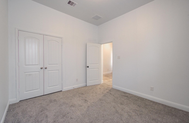unfurnished bedroom with carpet, baseboards, and a closet