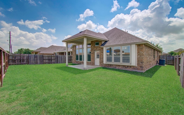 back of property featuring brick siding, roof with shingles, central AC unit, and a patio