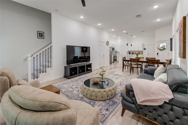 living area featuring stairway, recessed lighting, and light wood finished floors