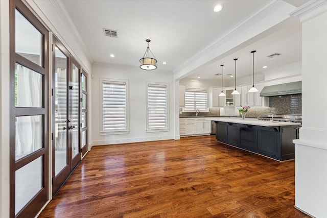6216 Queenswood Ln, Houston, TX 77008 - kitchen with exhaust hood, french doors, white cabinets, decorative backsplash, and light countertops