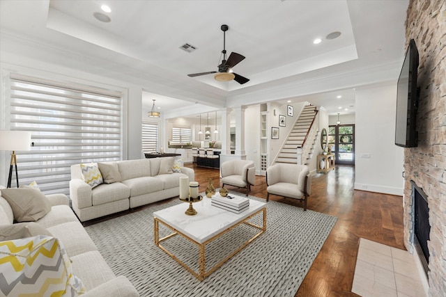 6216 Queenswood Ln, Houston, TX 77008 - living area with a ceiling fan, a stone fireplace, stairway, a raised ceiling, and wood finished floors