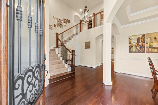 18814 Luby Creek Dr, Cypress, TX 77433 - foyer entrance featuring arched walkways, dark wood-style flooring, a chandelier, stairs, and baseboards
