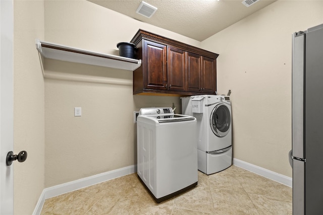 18814 Luby Creek Dr, Cypress, TX 77433 - laundry area with washing machine and dryer, cabinet space, baseboards, light tile patterned floors, and a textured ceiling