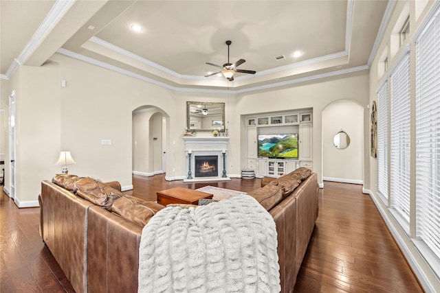 18814 Luby Creek Dr, Cypress, TX 77433 - living area featuring ceiling fan, arched walkways, a raised ceiling, dark wood-style floors, and ornamental molding