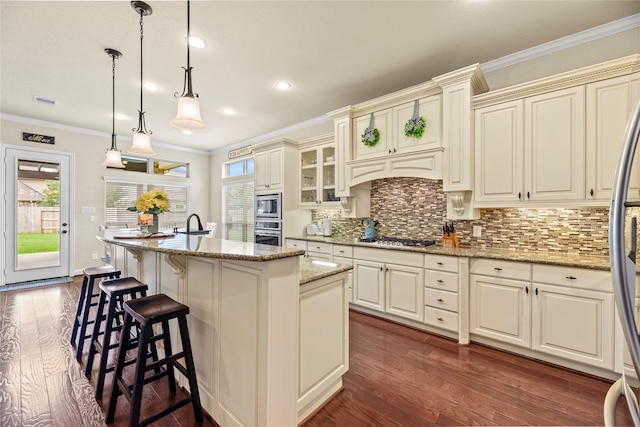 18814 Luby Creek Dr, Cypress, TX 77433 - kitchen with stainless steel appliances, dark wood-style floors, backsplash, a center island with sink, and light stone counters