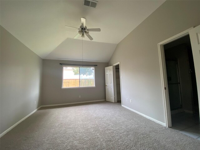 unfurnished bedroom with carpet, baseboards, vaulted ceiling, and ceiling fan