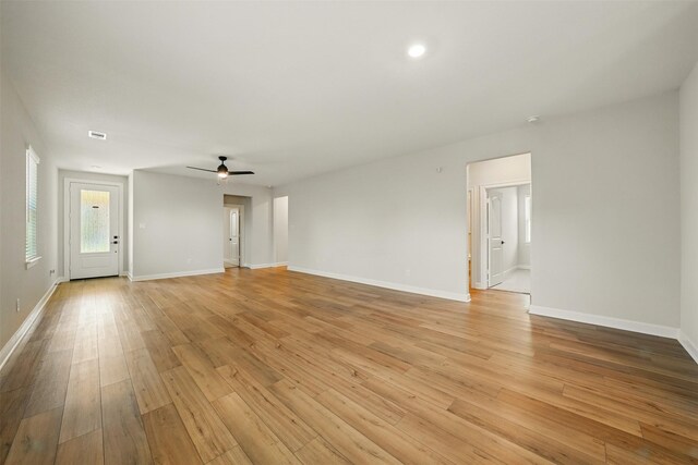 820 Dawn Redwood Ct, Conroe, TX 77304 - unfurnished living room featuring a ceiling fan, baseboards, and light wood-style flooring