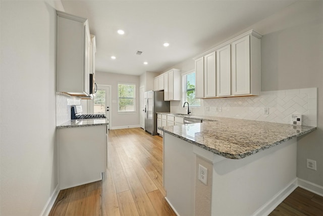 820 Dawn Redwood Ct, Conroe, TX 77304 - kitchen with appliances with stainless steel finishes, baseboards, light stone counters, and recessed lighting