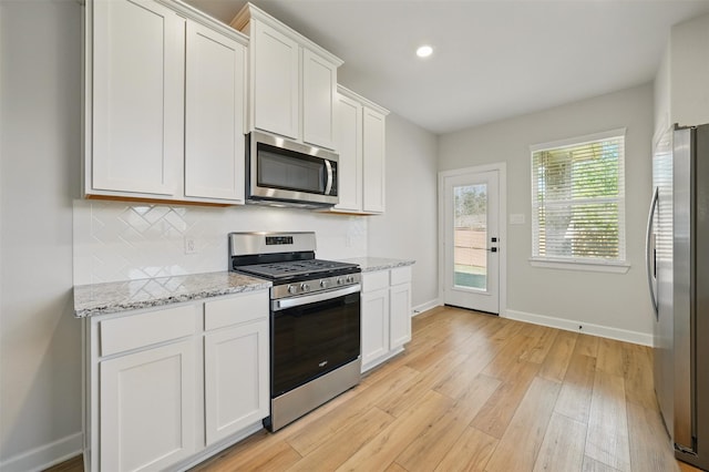 820 Dawn Redwood Ct, Conroe, TX 77304 - kitchen with appliances with stainless steel finishes, baseboards, tasteful backsplash, white cabinetry, and recessed lighting