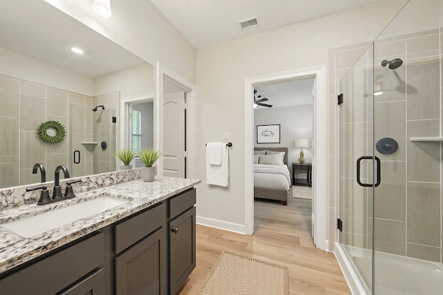 820 Dawn Redwood Ct, Conroe, TX 77304 - full bathroom with a stall shower, wood finished floors, vanity, connected bathroom, and baseboards