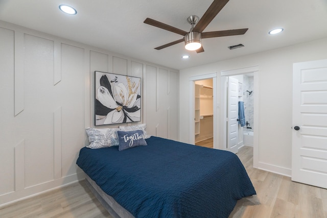 3618 Tamfield Dr, Houston, TX 77066 - bedroom featuring light wood-style flooring, a decorative wall, recessed lighting, a walk in closet, and a ceiling fan