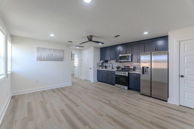 3618 Tamfield Dr, Houston, TX 77066 - kitchen featuring stainless steel appliances, a sink, light countertops, baseboards, and tasteful backsplash