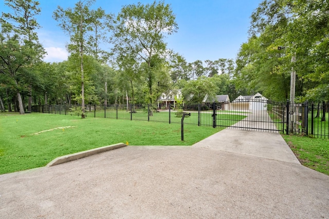 10 Hollow Glen Ln, Tomball, TX 77375 - view of home's community with a gate, view of wooded area, and driveway