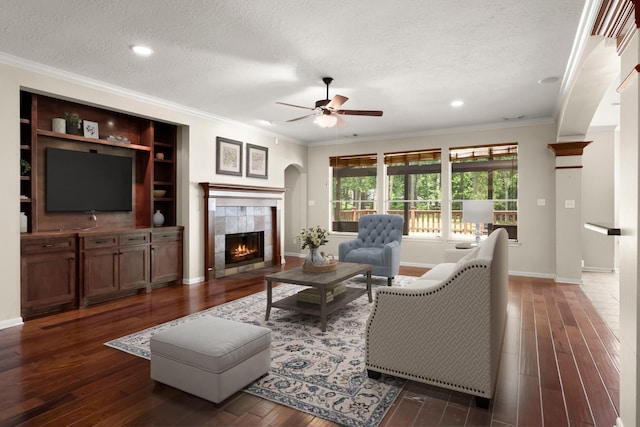 10 Hollow Glen Ln, Tomball, TX 77375 - living room with crown molding, ceiling fan, hardwood / wood-style flooring, a fireplace, and a textured ceiling