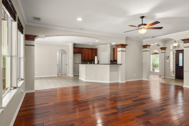 10 Hollow Glen Ln, Tomball, TX 77375 - unfurnished living room featuring arched walkways, light wood-style flooring, ceiling fan, recessed lighting, and baseboards