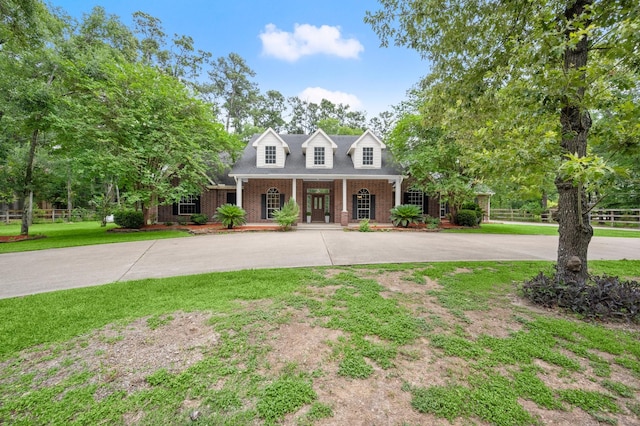 10 Hollow Glen Ln, Tomball, TX 77375 - cape cod house with a porch, brick siding, and curved driveway
