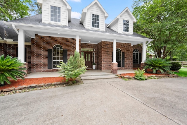 10 Hollow Glen Ln, Tomball, TX 77375 - cape cod house with brick siding, covered porch, and roof with shingles