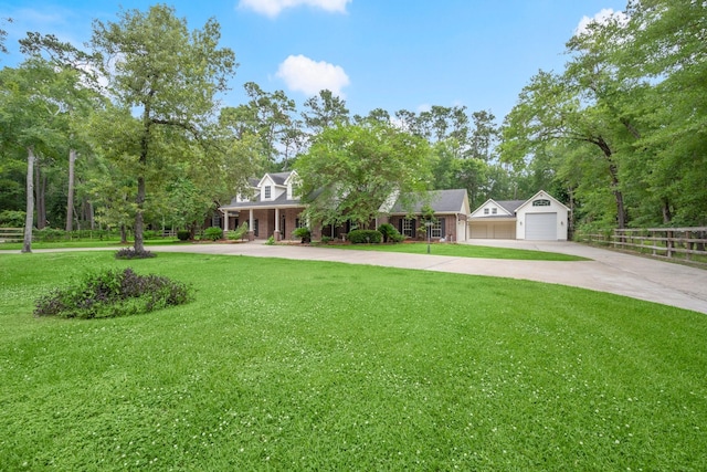 10 Hollow Glen Ln, Tomball, TX 77375 - view of front of house with a detached garage, concrete driveway, view of scattered trees, and a porch