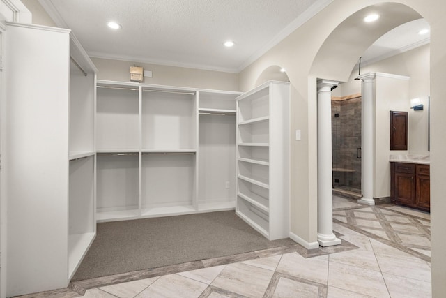 10 Hollow Glen Ln, Tomball, TX 77375 - walk in closet featuring inlaid floor details, ornate columns, and arched walkways