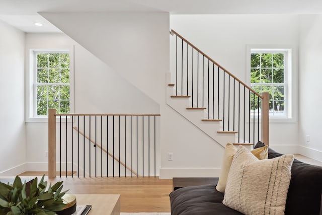 staircase with wood finished floors, recessed lighting, and baseboards