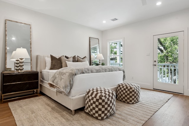 bedroom featuring access to exterior, light wood-style floors, recessed lighting, and baseboards