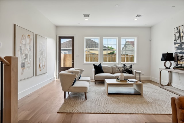 living area with wood finished floors, baseboards, and recessed lighting
