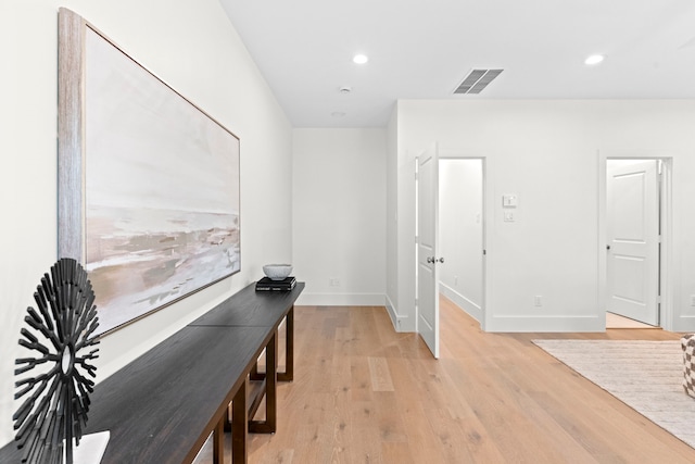 hall with light wood-style flooring, baseboards, and recessed lighting
