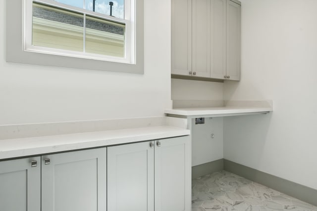 laundry room featuring cabinet space and baseboards