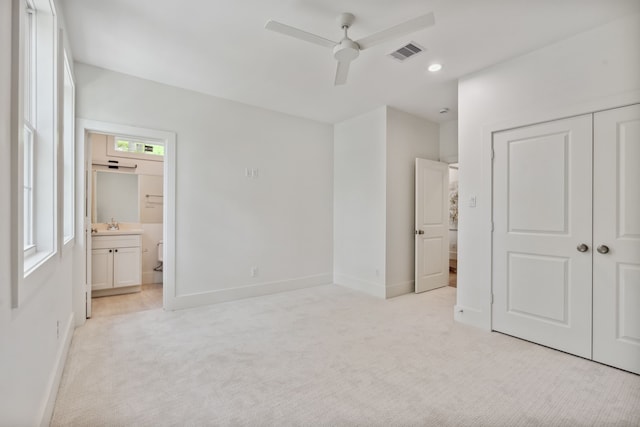 unfurnished bedroom with light colored carpet, a closet, and baseboards