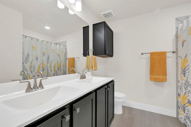 2108 Eagle Nook Dr, Texas City, TX 77568 - bathroom featuring wood finished floors, toilet, baseboards, double vanity, and curtained shower