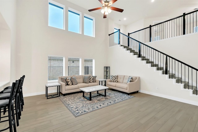 2108 Eagle Nook Dr, Texas City, TX 77568 - living area with a ceiling fan, baseboards, light wood-type flooring, stairway, and a towering ceiling