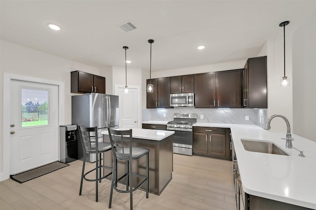2108 Eagle Nook Dr, Texas City, TX 77568 - kitchen with stainless steel appliances, a sink, a kitchen bar, dark brown cabinets, and tasteful backsplash