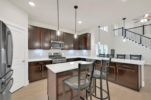 2108 Eagle Nook Dr, Texas City, TX 77568 - kitchen with stainless steel appliances, a peninsula, dark brown cabinets, tasteful backsplash, and recessed lighting