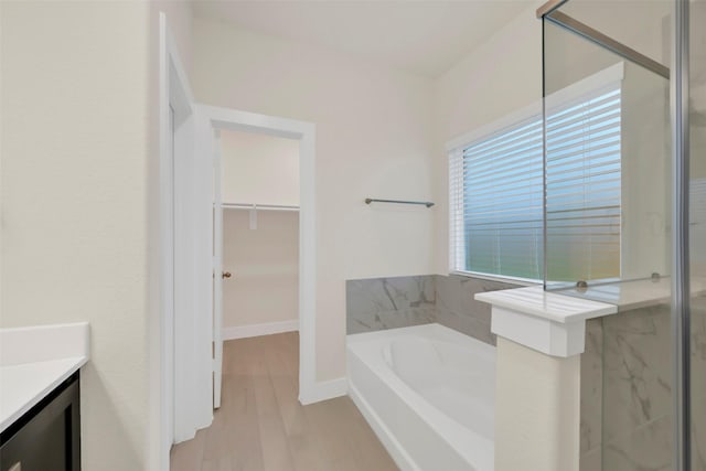 2108 Eagle Nook Dr, Texas City, TX 77568 - full bathroom featuring vanity, a bath, a shower stall, wood finished floors, and a walk in closet